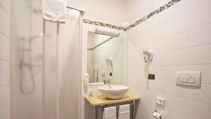 A bathroom with a white sink, a mirror, a towel rack, a hairdryer, and a toilet. - Hotel Master (Turin)