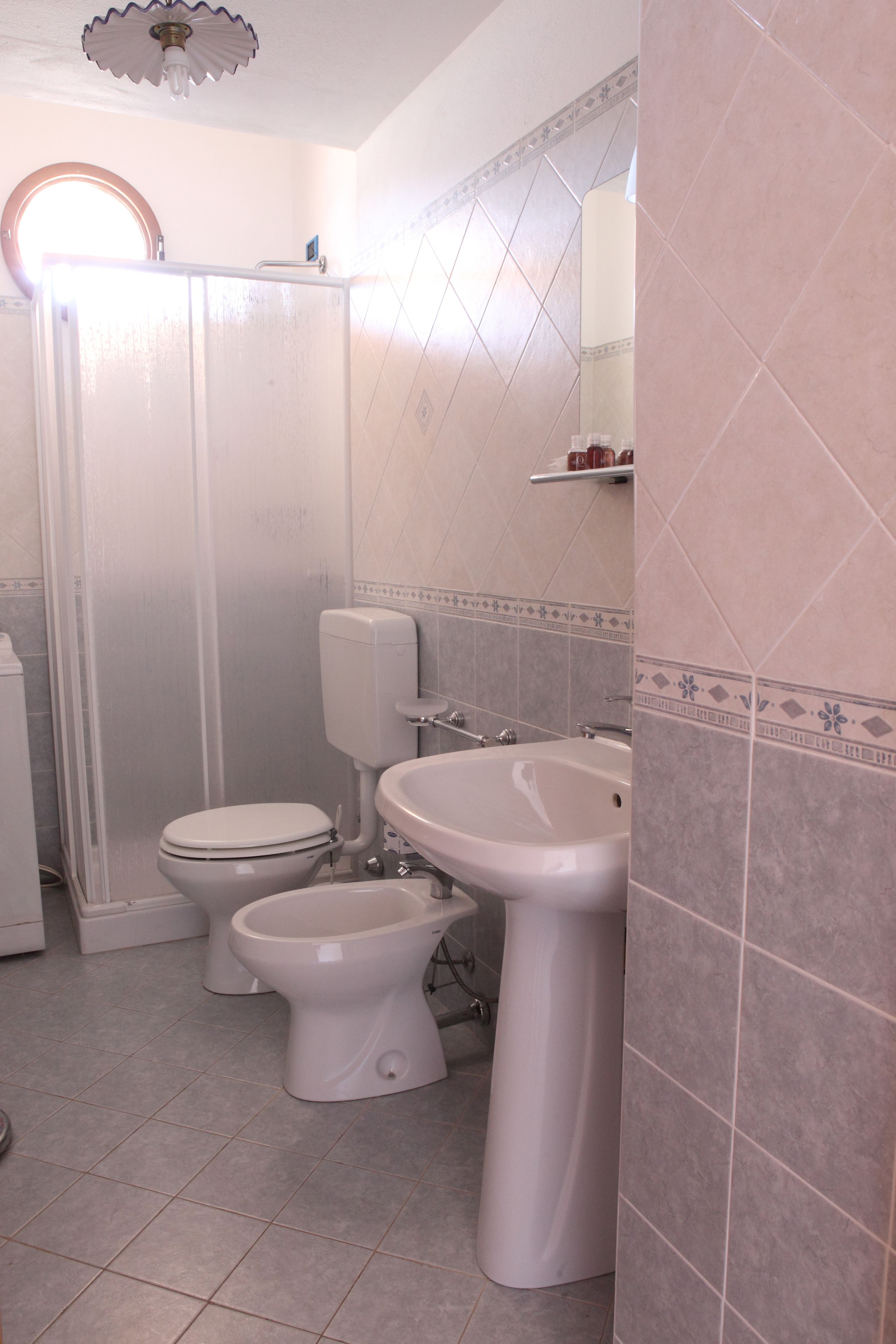 A bathroom with a toilet, bidet, and sink.