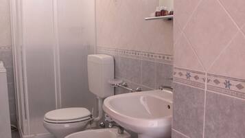 A bathroom with a toilet, bidet, and sink.