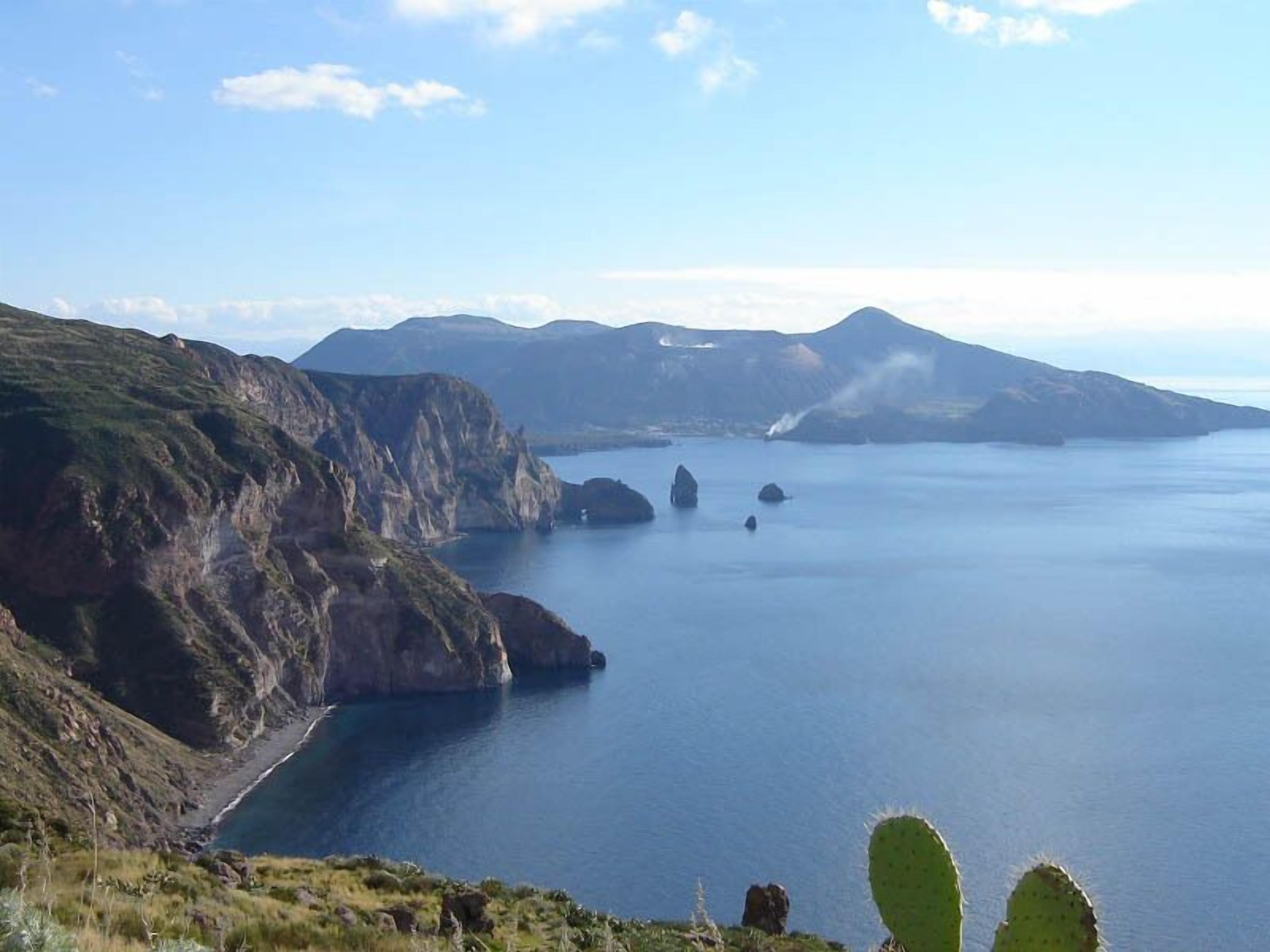 A coastal landscape with cliffs and a calm sea.