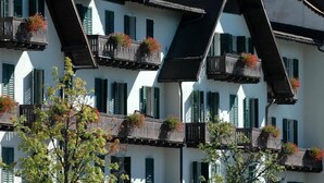 A multi-story building with balconies adorned with flower boxes. - TH San Martino | Majestic Dolomiti Hotel (Primiero San Martino di Castrozza)