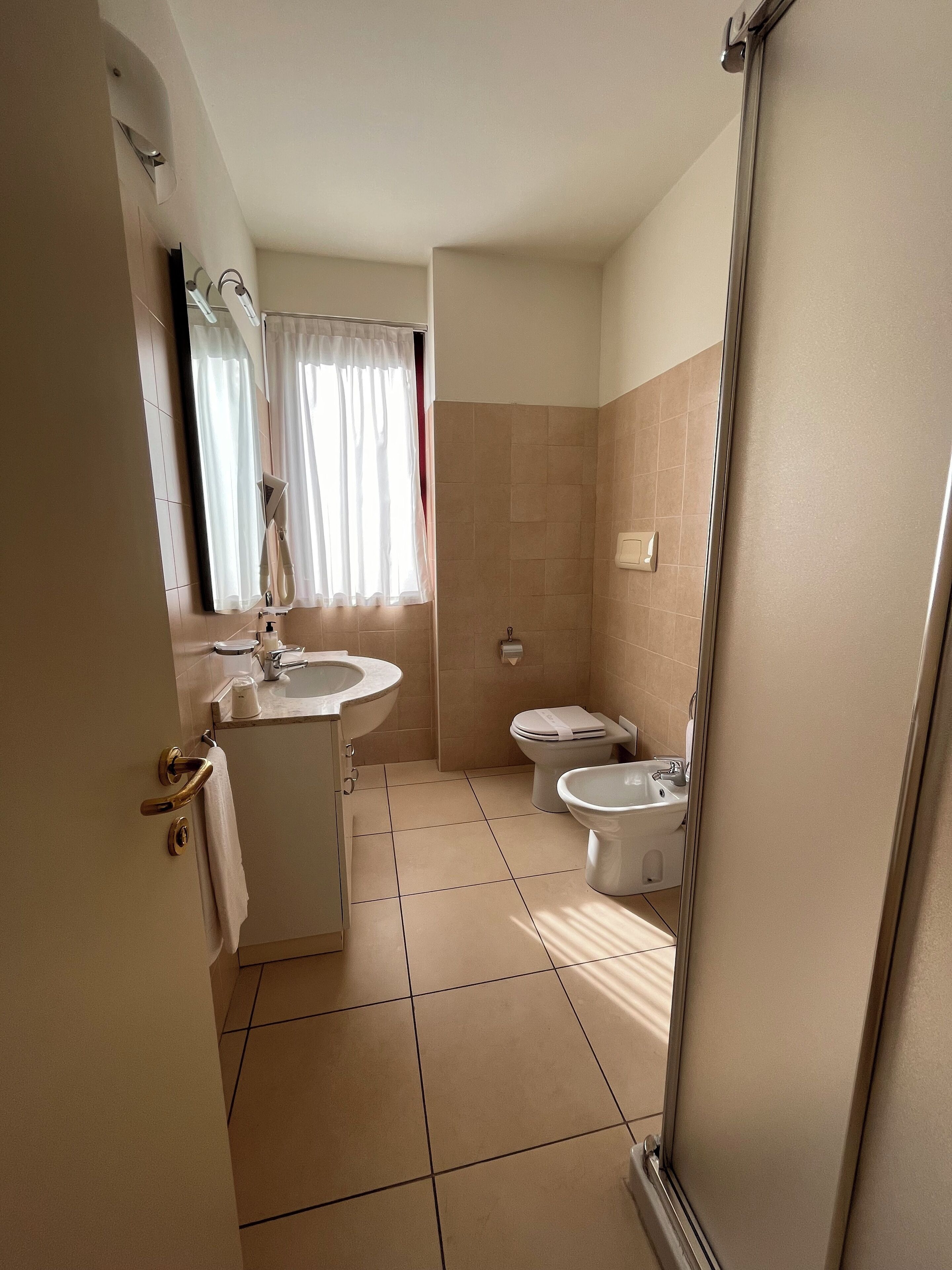 Et badeværelse med toilet, bidet og håndvask.