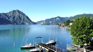 A marina with boats docked, a dock with a sign reading "HOTEL LOVER", and a backdrop of mountains. - Hotel Lovere Resort & Spa (Lovere)