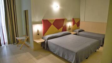 Une chambre d’hôtel avec deux lits, un petit bureau et une chaise.