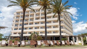 A multi-story hotel with balconies, palm trees, and sun loungers. - Cala Millor Garden, Adults Only (Sant Llorenc des Cardassar)