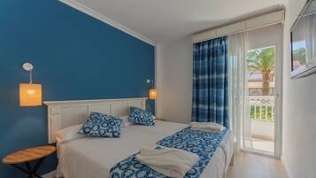 Ein Zimmer mit Bett, Nachttisch und einem Vorhangfenster.