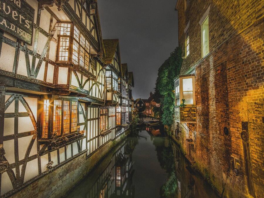 A narrow canal flanked by historic buildings with timber framing and brick walls.