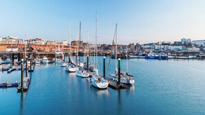 A marina with numerous sailboats docked at piers, surrounded by buildings and a clear sky. - Holiday Inn Express Ramsgate - Minster by IHG (Ramsgate)