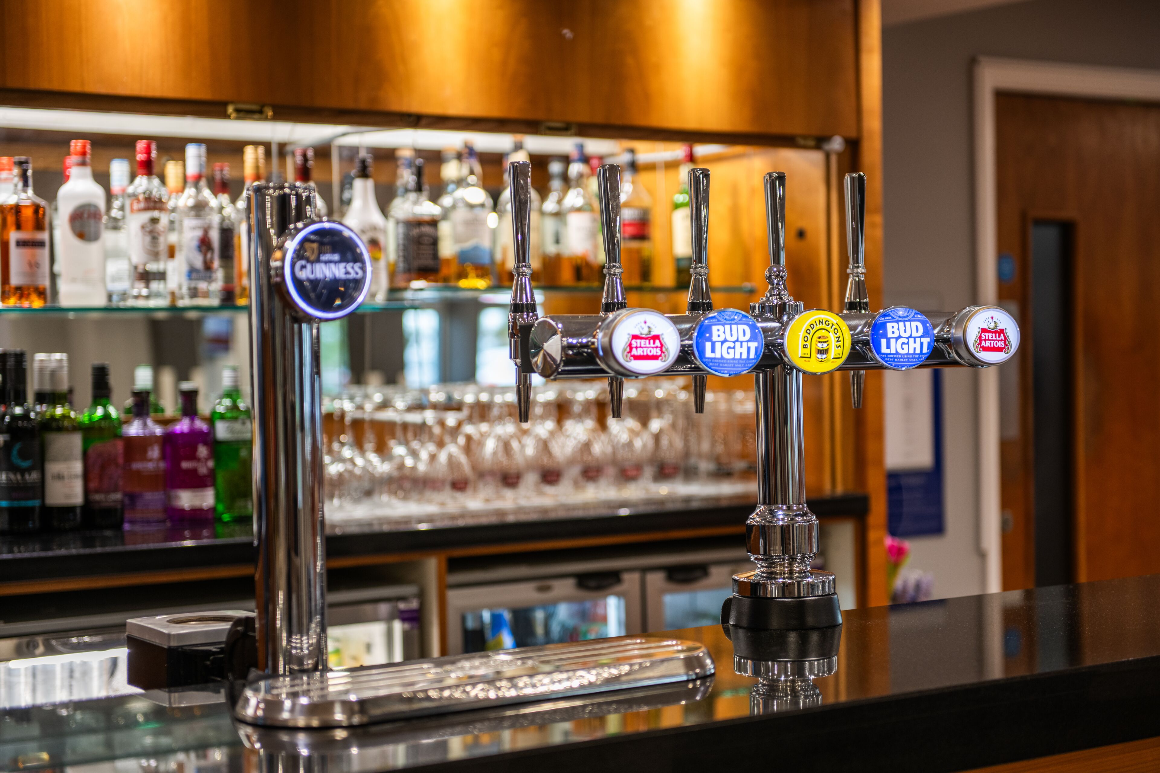Un bar con múltiples grifos, incluyendo marcas como Guinness, Stella Artois y Bud Light.