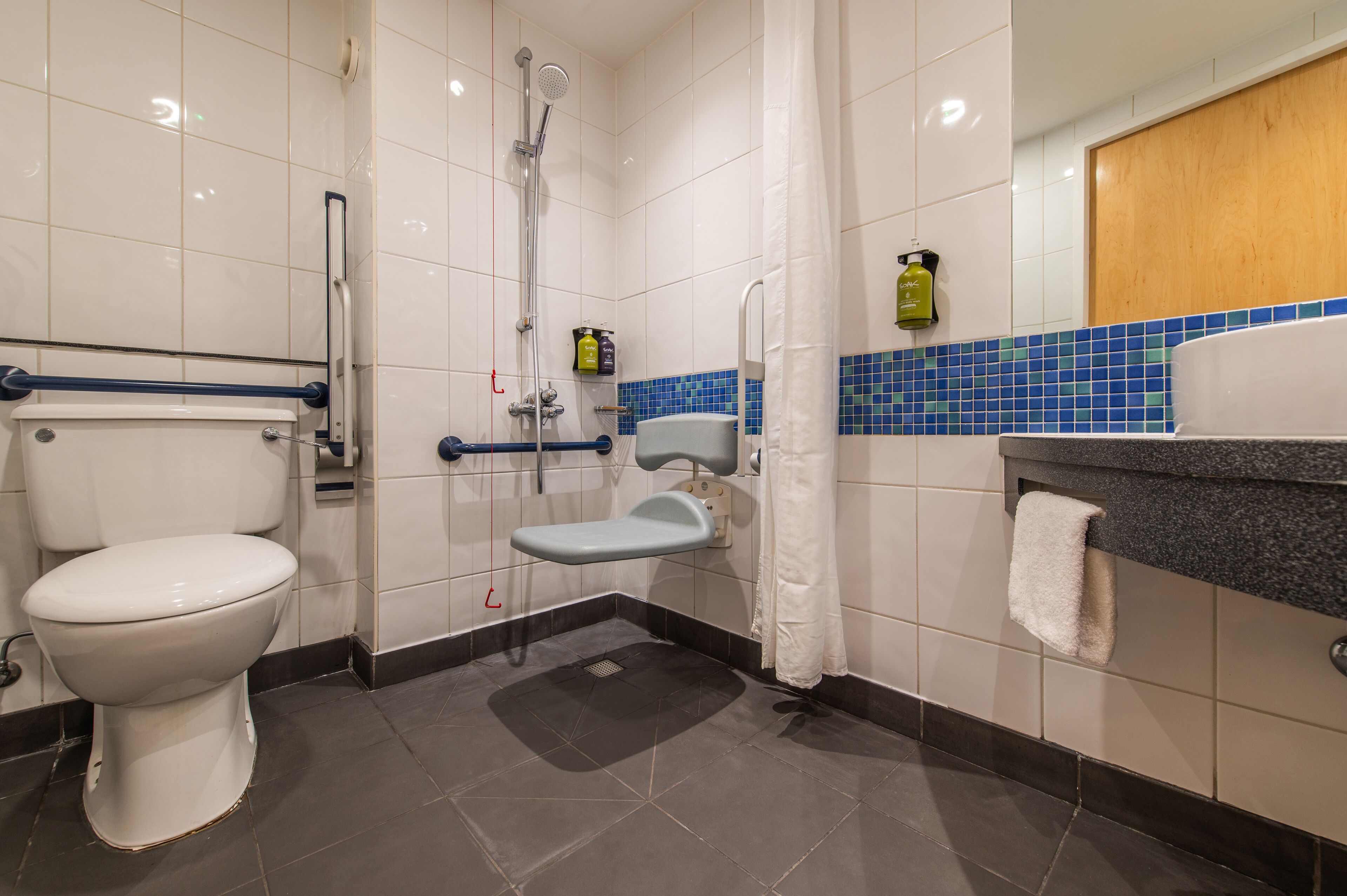 A modern bathroom with a toilet, a shower, and a sink.