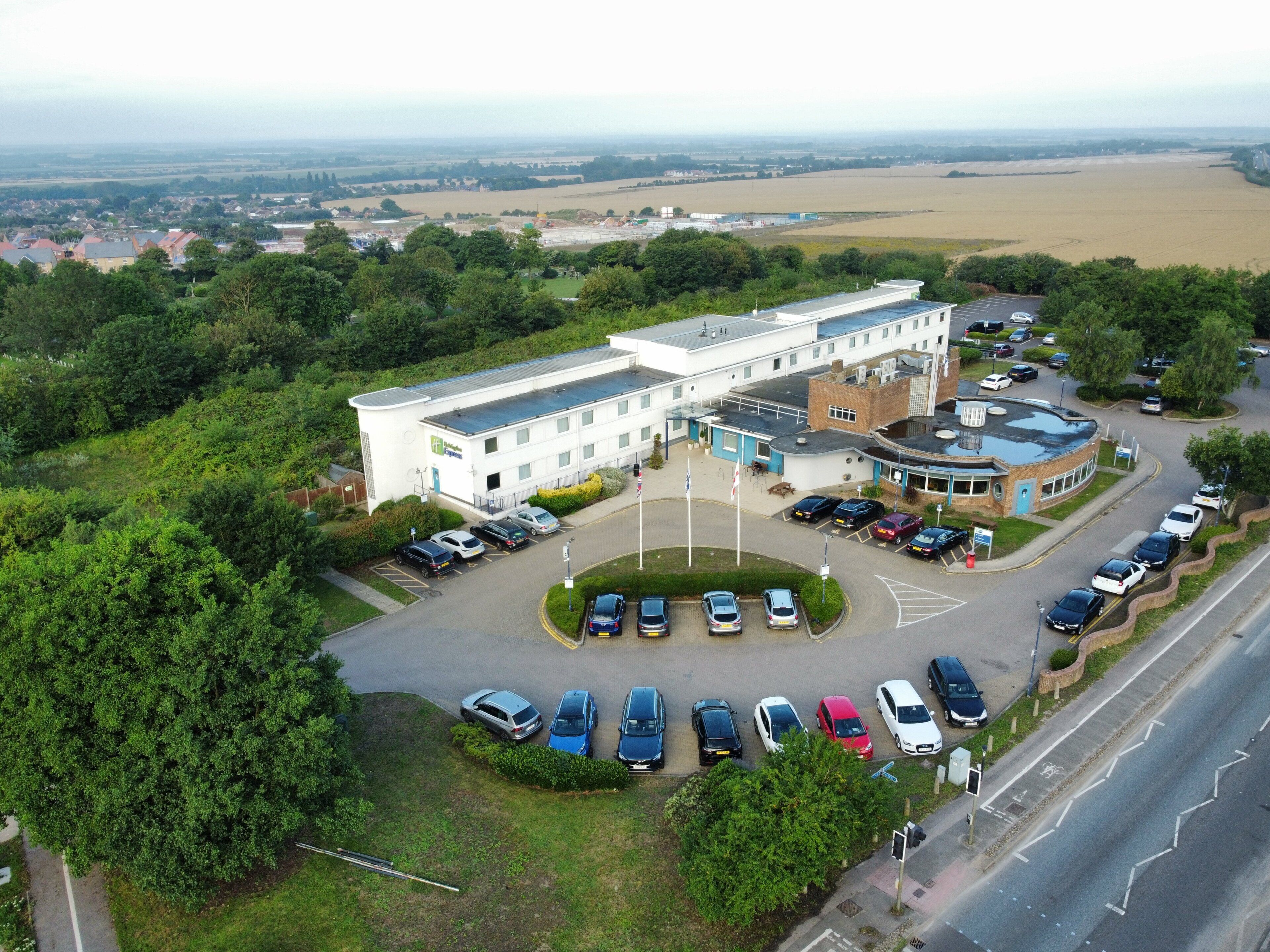 A large building with a parking lot and a roundabout.