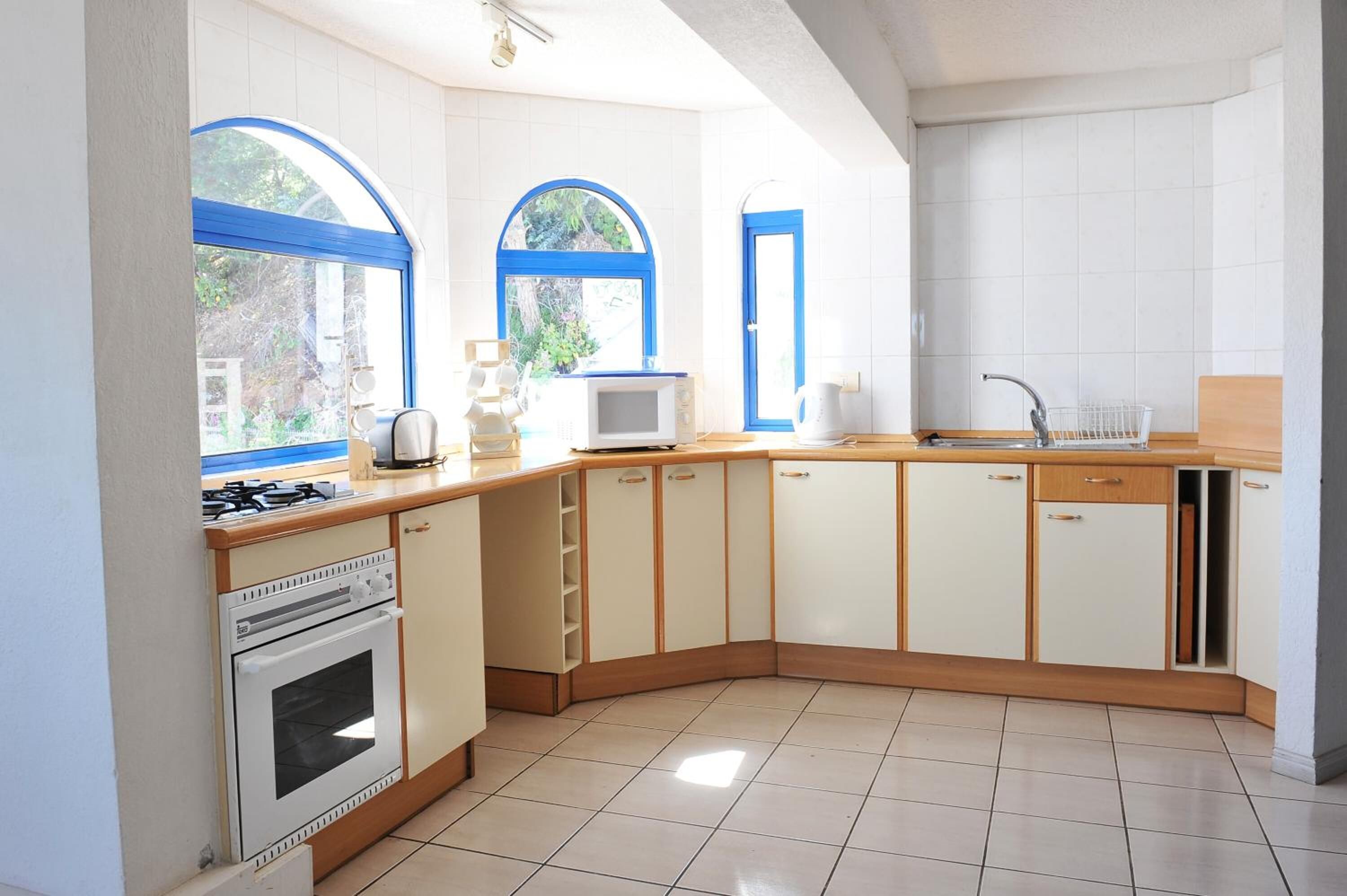 Cocina compacta equipada con estufa, horno, microondas y pileta.