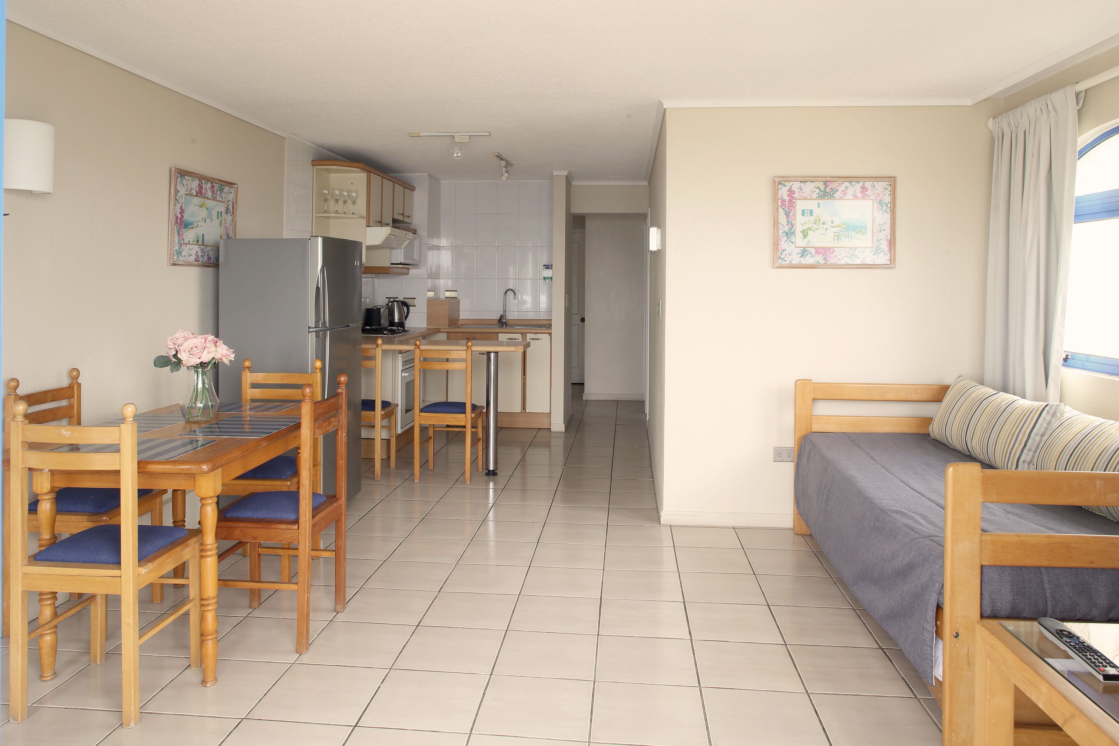 Un espacio habitable compacto con kitchenette, comedor y sofá.