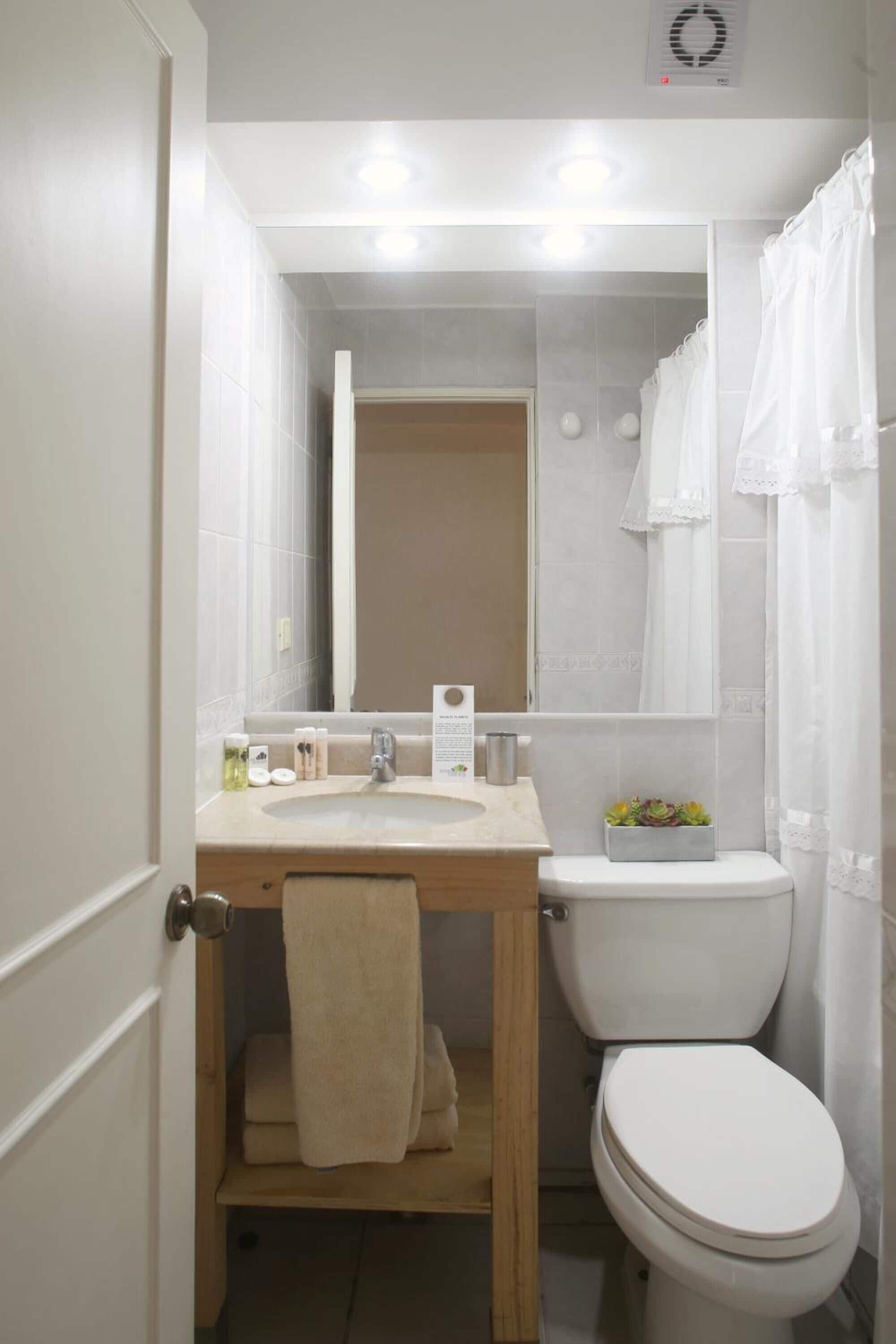 Une petite salle de bain comprenant un lavabo, un miroir et des toilettes.