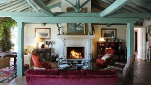 A cozy living room with a fireplace, comfortable seating, and a rustic ceiling. - Valdepalacios (Torrico)