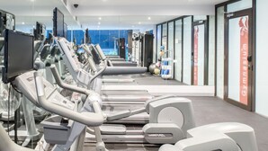 A gym with treadmills, weight machines, and exercise balls.