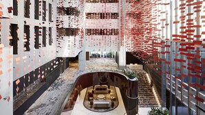 A modern lobby with a central seating area, a staircase, and a patterned wall design. - Hotel Realm (Barton)