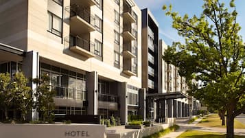 Experience the sleek, modern design of Hotel Realm, featuring a symmetrical facade, large windows, and balconies.