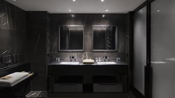 Un baño moderno con dos lavamanos, un espejo y un perchero para toallas.