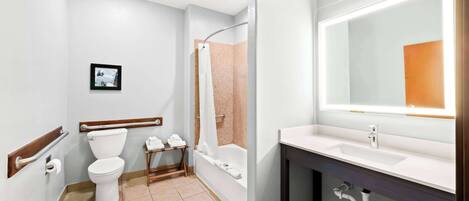 A modern bathroom with a toilet, sink, and bathtub.