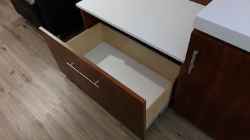 Un mueble de madera con encimera blanca y un cajón.
