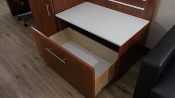 A wooden desk with a white top and a drawer.