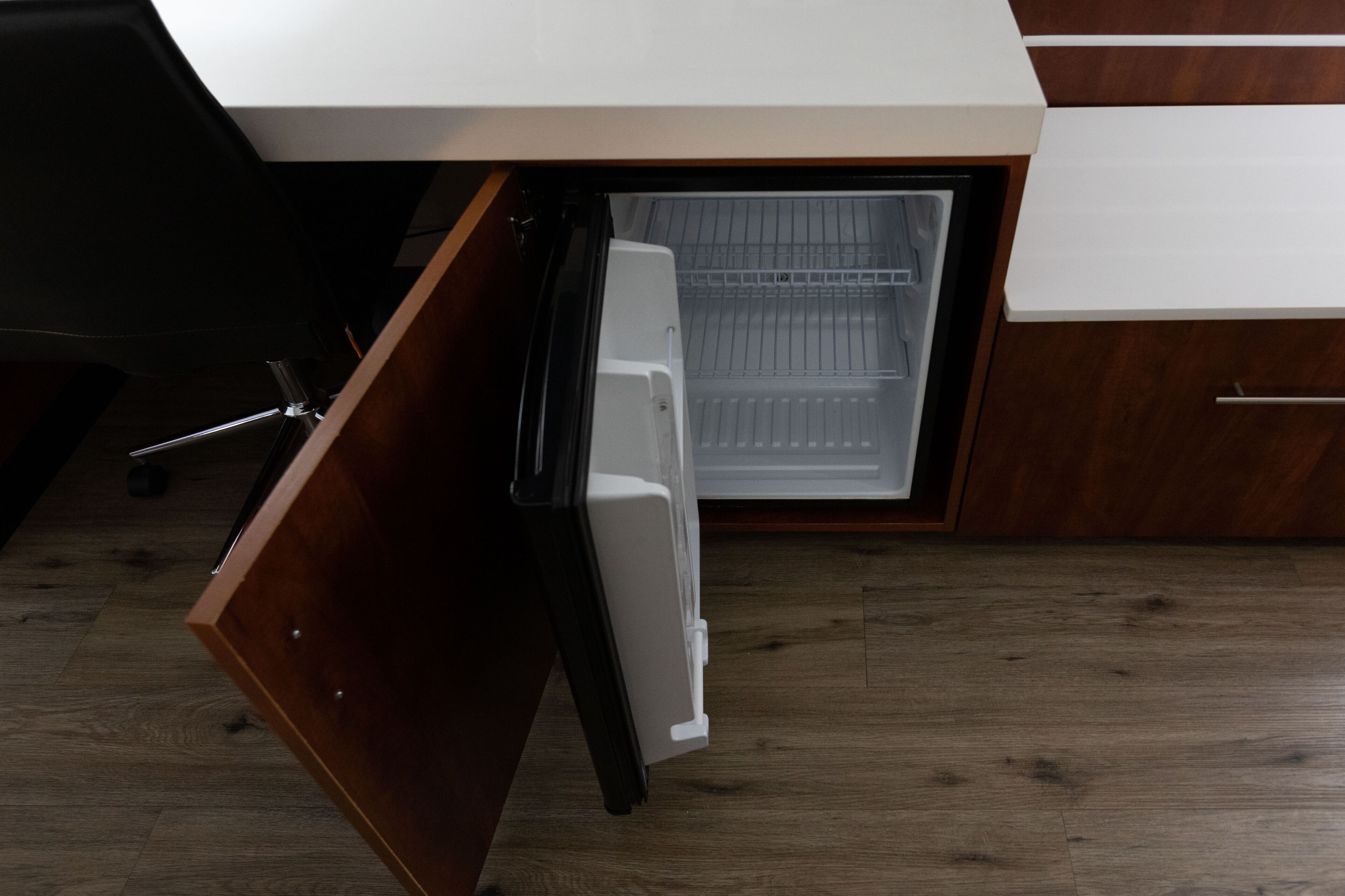 Una cocina con un refrigerador blanco, armarios de madera y un lavamanos de acero inoxidable.