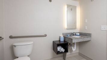 A modern bathroom with a toilet, a sink, and a mirror.