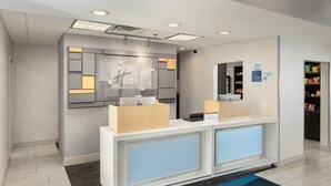 A reception area with a modern design, featuring a reception desk, a digital display, and a check-in counter. - Holiday Inn Express & Suites Carrollton by IHG (Carrollton)