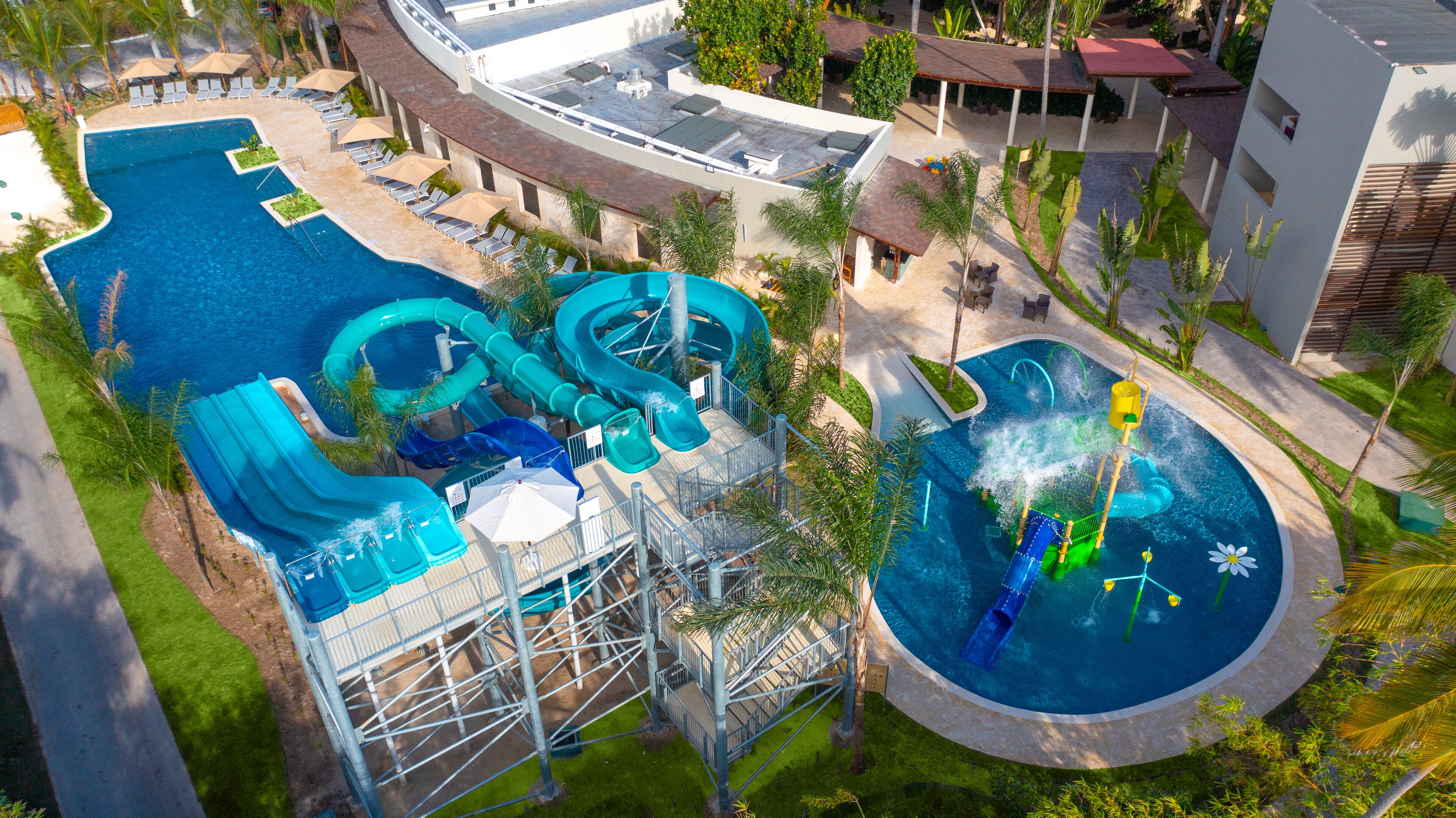 A large outdoor swimming pool with multiple water slides and a separate circular pool area.