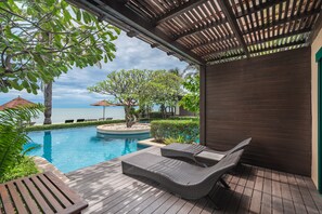 A wooden deck with a pool, lounge chairs, and a view of the sea. - Aleenta Hua Hin - Pranburi (Pranburi)