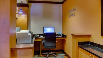 A hotel office with a desk, computer, printer, and a sign reading "Connect & Print".