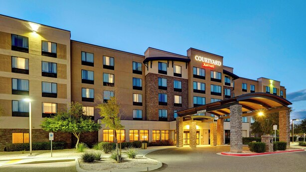 A Courtyard Marriott hotel with a modern design, featuring multiple floors, a covered entrance, and well-lit surroundings. - Courtyard by Marriott Phoenix North/Happy Valley (Phoenix)