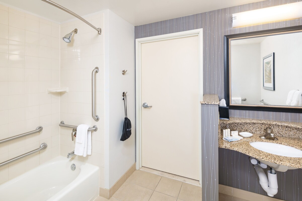 A modern bathroom with a bathtub, a sink, and a shower.