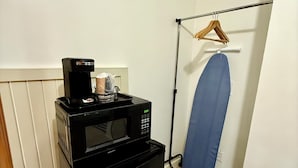 A compact kitchenette with a microwave and a small refrigerator.