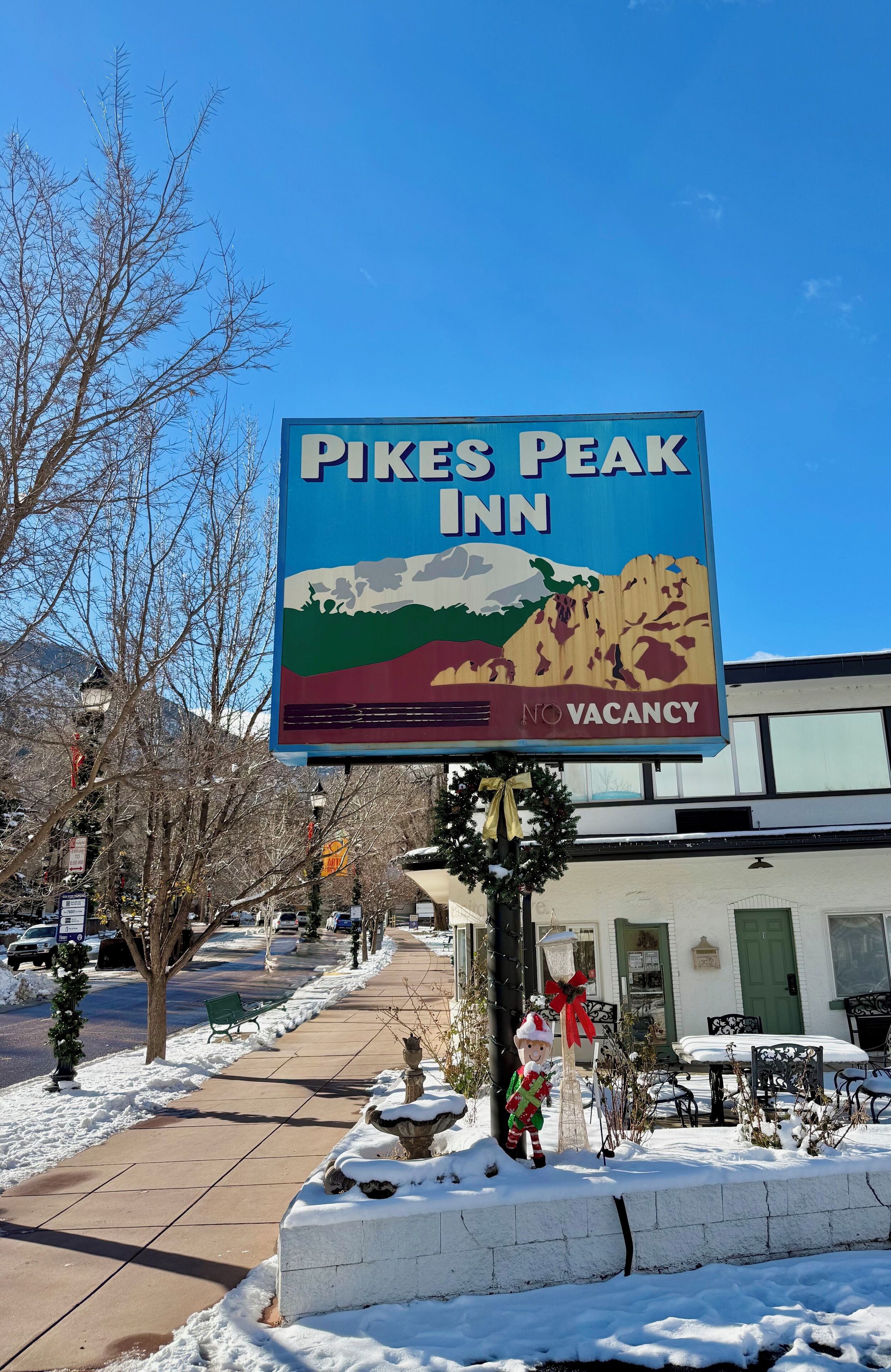 Une enseigne indiquant l’hôtel Pikes Peak Inn, avec une affiche « Complet ».
