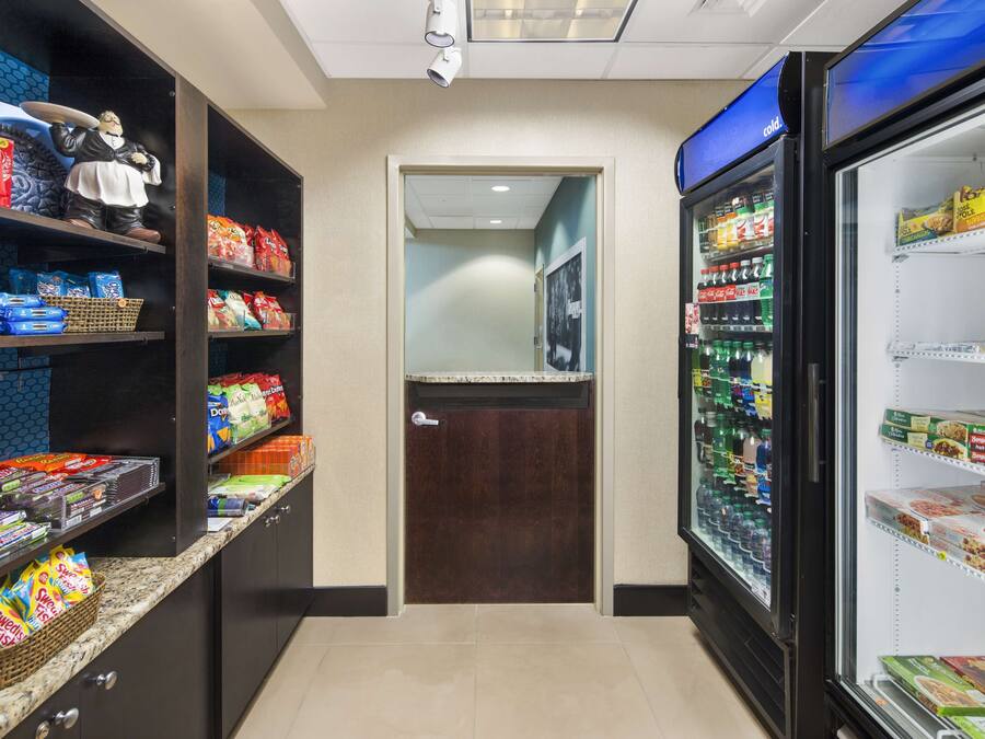 A snack bar with shelves stocked with various snacks and a freezer with frozen food items.