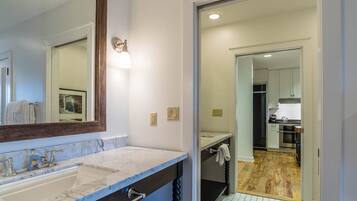 A bathroom with a marble sink, a large mirror, and a towel hanging on the wall.