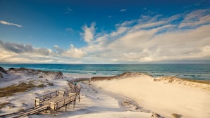 A wooden boardwalk leading to a sandy beach with a clear view of the ocean. - WaterSound Inn (Santa Rosa Beach)