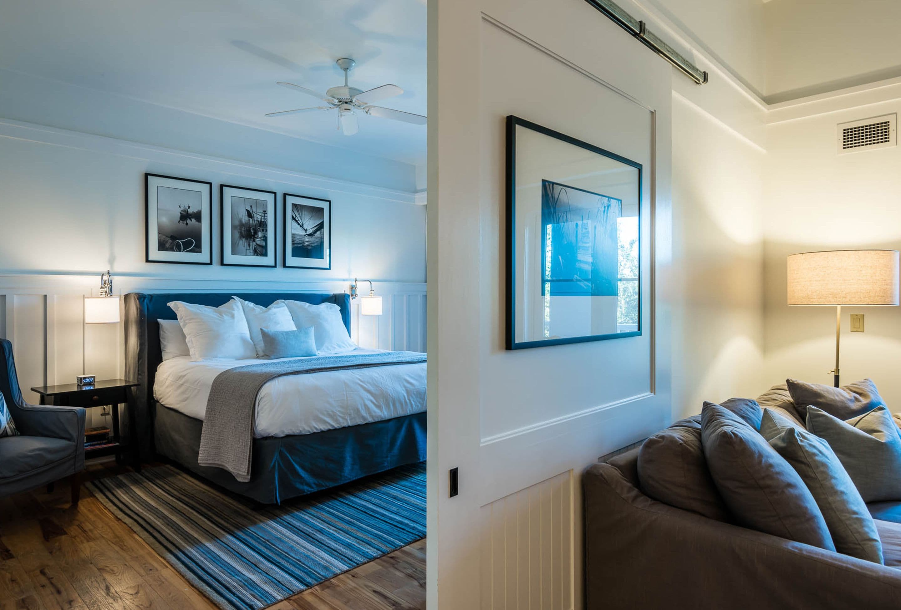 Une chambre d’hôtel avec un grand lit, un canapé, un bureau et un ventilateur de plafond.