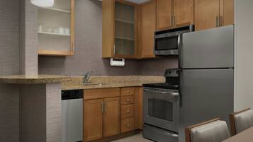 A modern kitchen with wooden cabinets, stainless steel appliances, and a granite countertop.