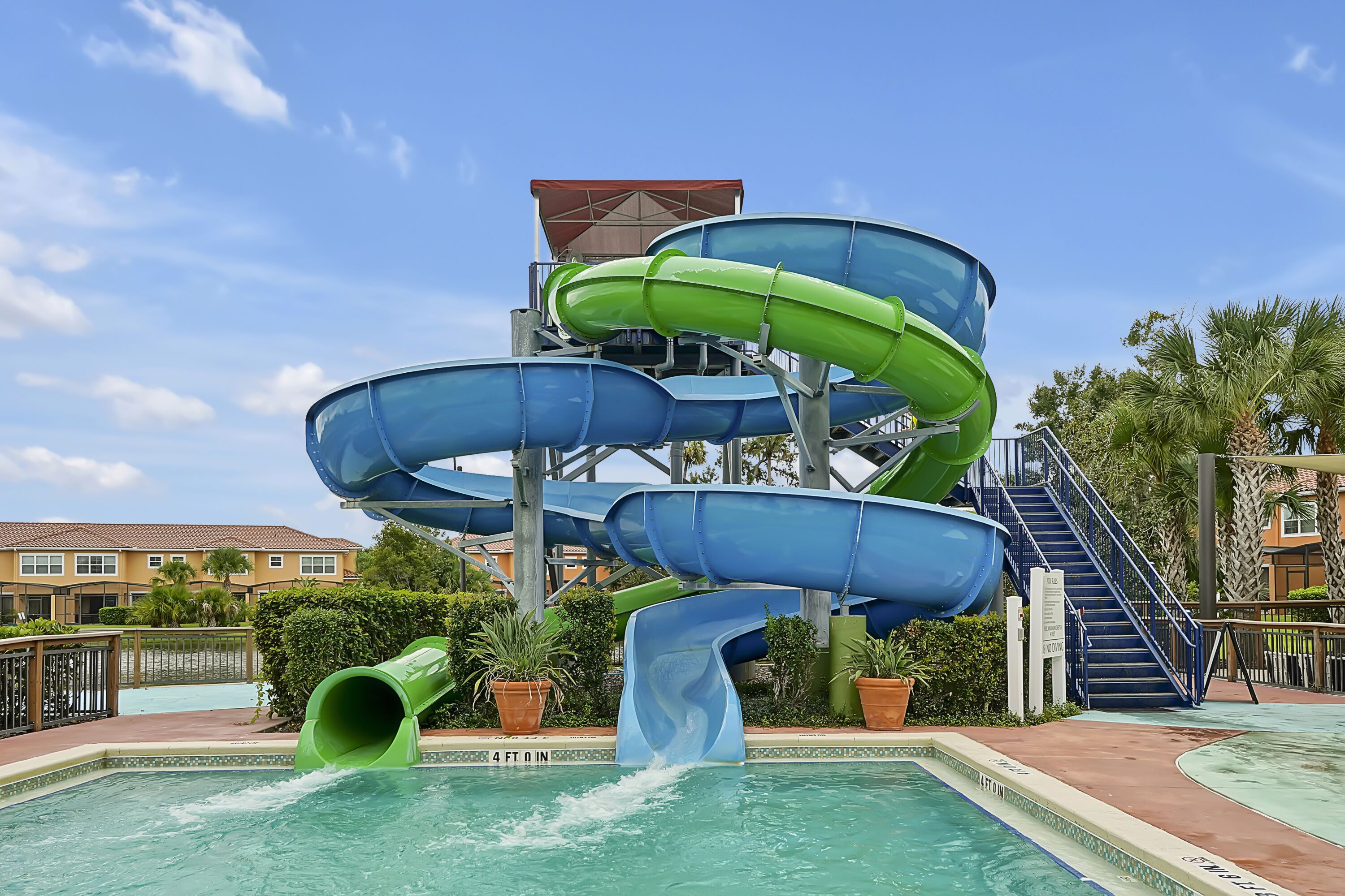 A water park with multiple slides, a pool, and a building with a red roof.