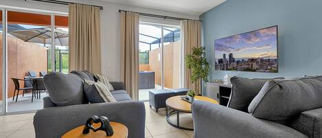 A modern living room with grey sofas, a wooden coffee table, and a cityscape painting on the wall.