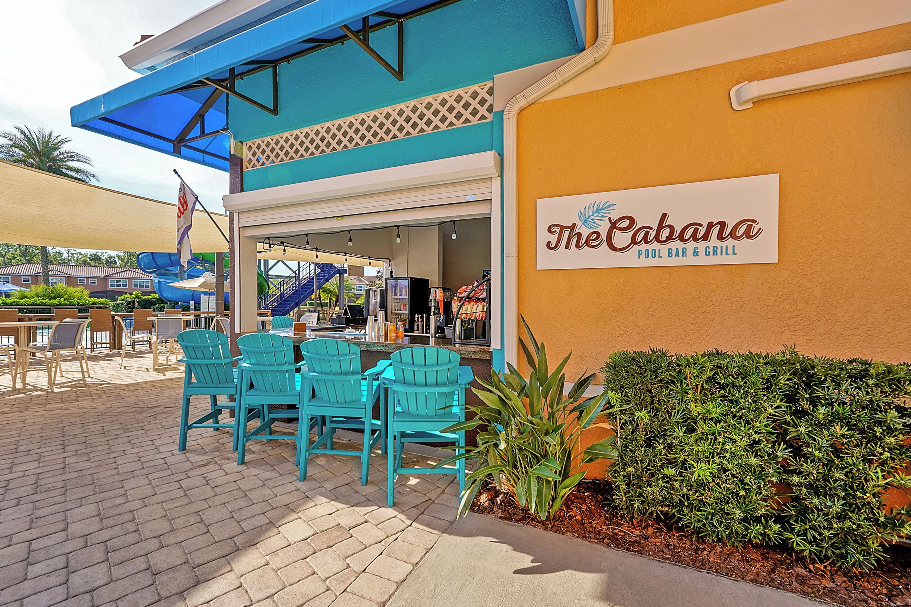 El bar y restaurante junto a la piscina Cabana, con mesas al aire libre y un letrero.