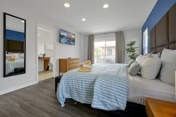 A modern living room with a grey sofa, two black ottomans, a wooden coffee table, and a staircase to the right. at Regal Oaks Resort Vacation Townhomes by IDILIQ