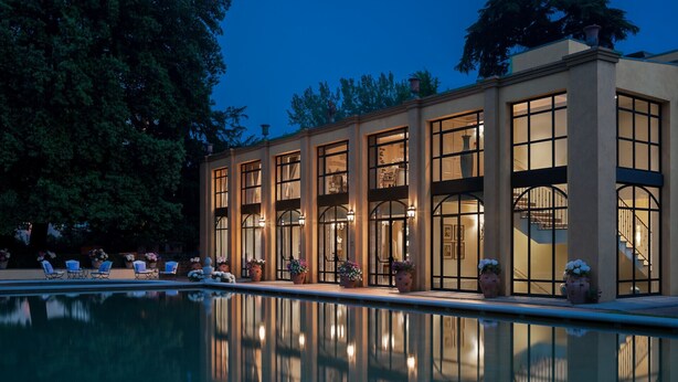 A building with large windows and a pool in front.