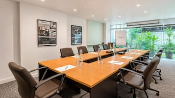 A conference room with a long table, chairs, and a whiteboard.