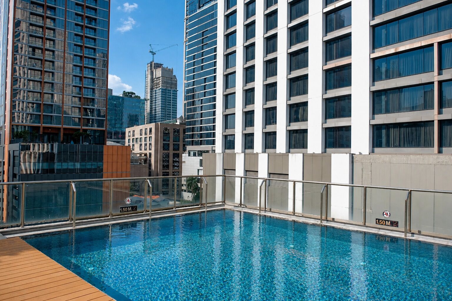 A rooftop swimming pool with a view of high-rise buildings.