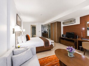 Una habitación de hotel con cama, escritorio, televisor y mesa de centro.