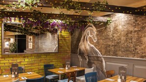A restaurant interior with brick walls, wooden tables, and chairs. - Coachman Hotel (Glasgow)